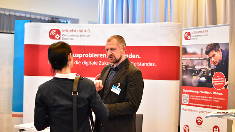 Christian Schilling informiert über die Angebote der Modellfabrik Produktionssteuerung (© Mittelstand 4.0-Kompetenzzentrum Ilmenau) 20181129 Christian Schilling informiert ueber die Angebote der Modellfabrik Produktionssteuerung