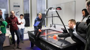 Die Teilnehmer spielen Air Hockey im IDMT (© Mittelstand 4.0-Kompetenzzentrum Ilmenau)