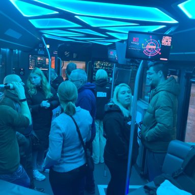 Mehrere Personen vor der Bar im Bus, eine Person trinkt aus einer Flasche