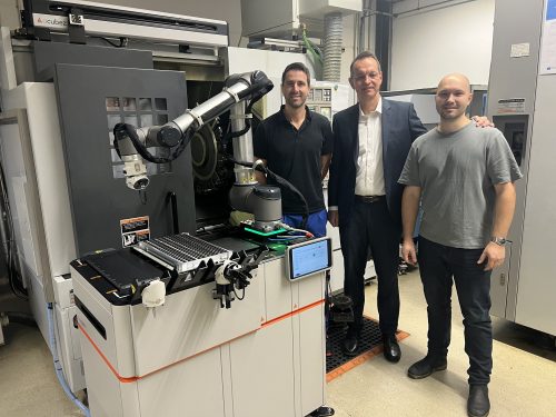 3 Männer stehen neben einem Gerät zur Automatisierungslösung