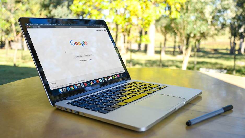 Ein Laptop auf dem die Google such geöffnet ist seht auf einem Café Tisch