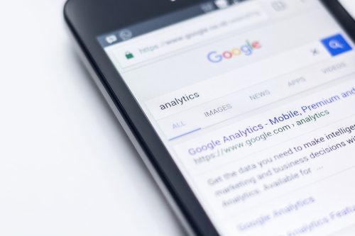 Smartphone auf dem Google geöffnet ist und die Suche "analytics" geöffnet ist
