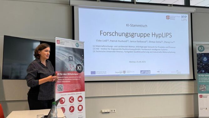 Eine Frau steht vor einer Präsentation und einem Roll-Up