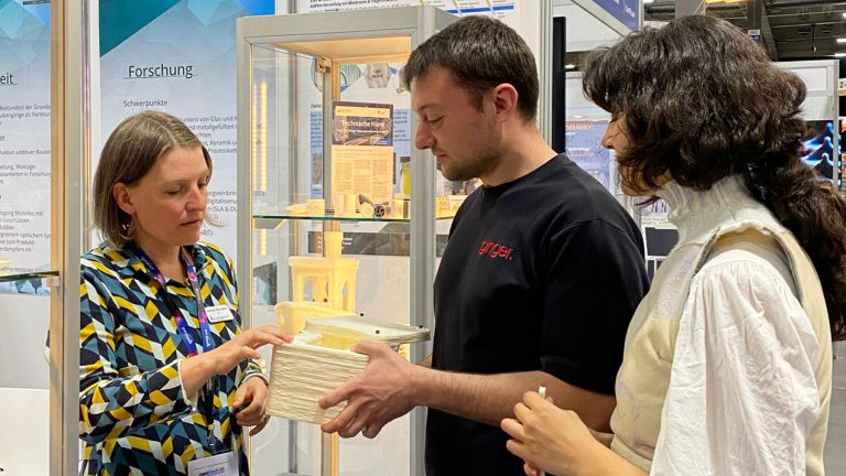 Drei Personen am Messestand auf der RapidTech