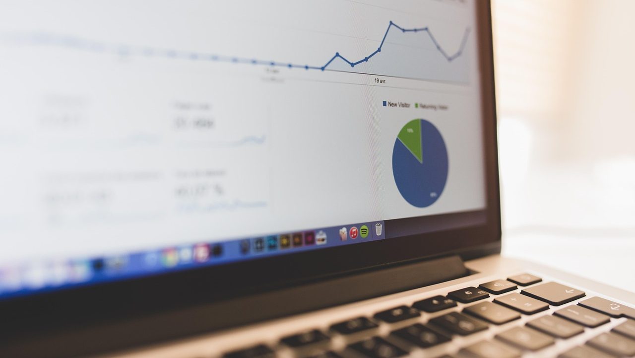 Datenanalyse Nahaufnahme eines Laptop-Bildschirms mit Datenanalyse-Dashboard, das ein Liniendiagramm und ein Kreisdiagramm mit den Kategorien ‚New Visitor‘ und ‚Returning Visitor‘ zeigt.